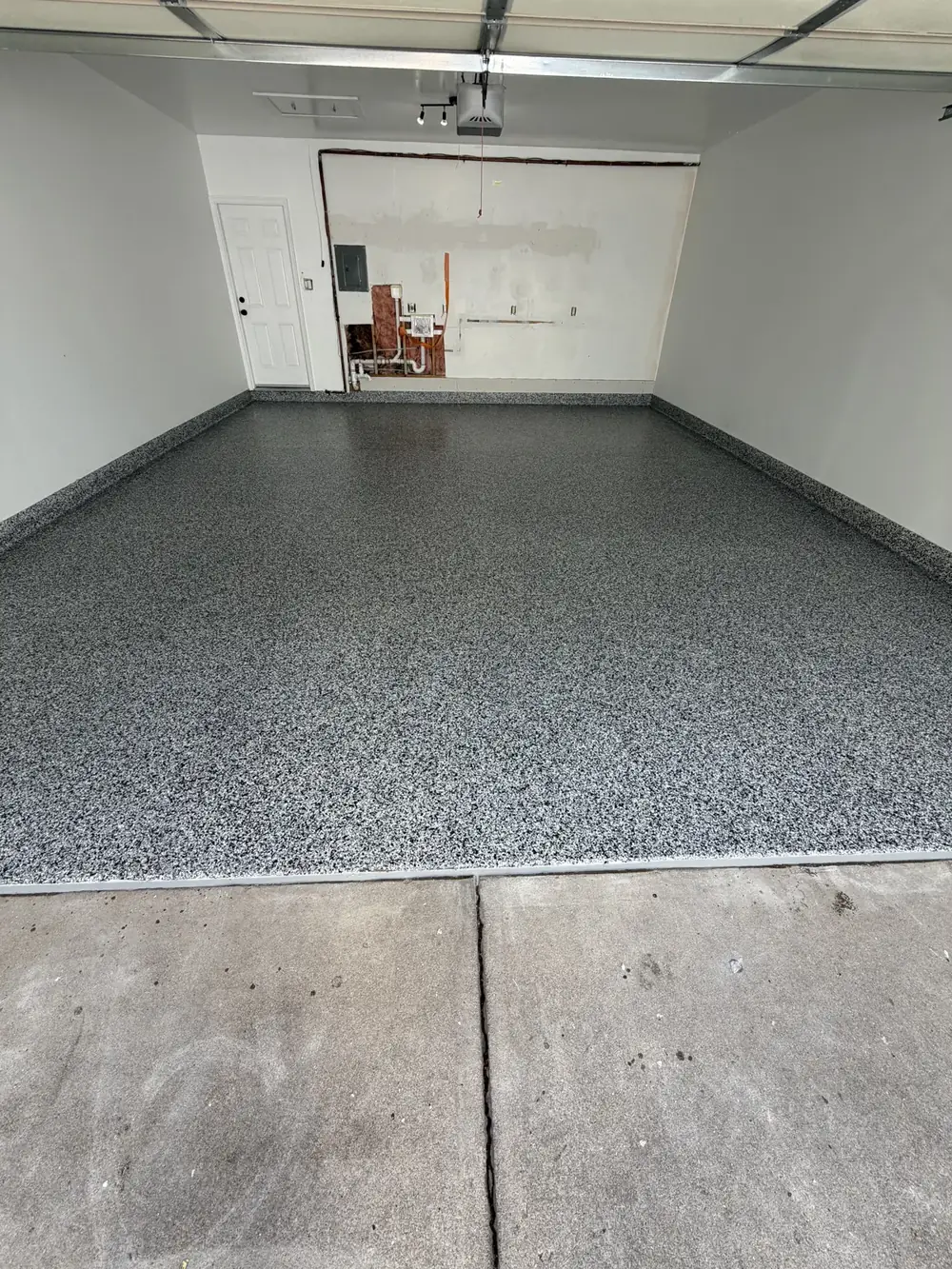Finished gray full-flake garage floor by Iron Cross Coatings, seen from the driveway