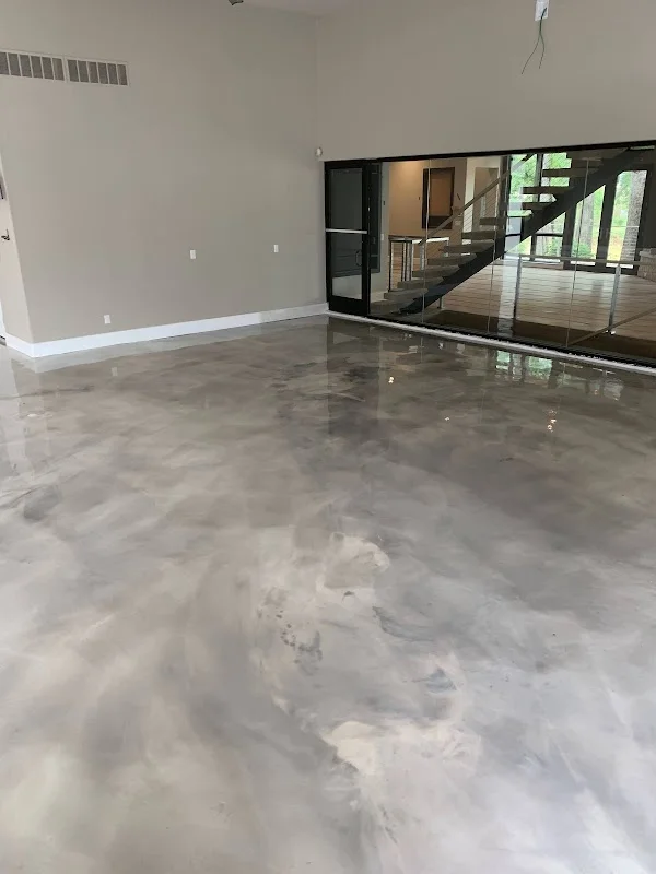 Gray and silver metallic epoxy floor in a bright open living space with a glass wall